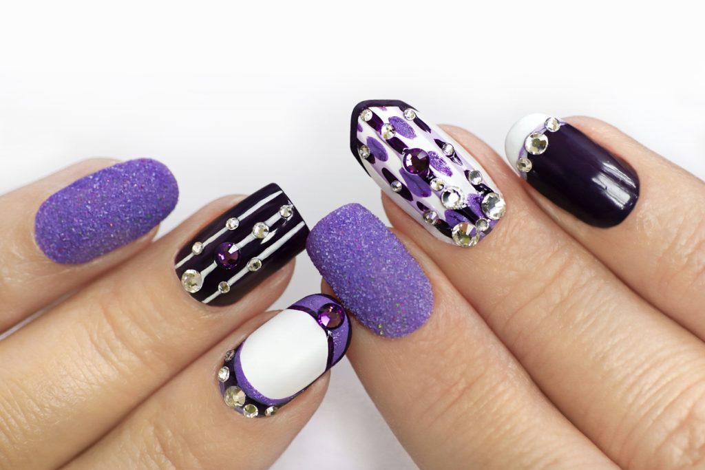 Multi-colored manicure with white and lilac varnish on various forms of nails